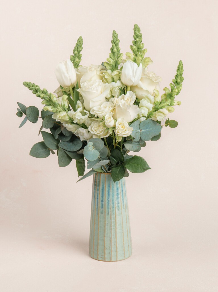 Paulette bouquet with 16 stems of white snapdragons, roses, tulips, and eucalyptus. A serene, premium arrangement ideal for thank yous or housewarmings.