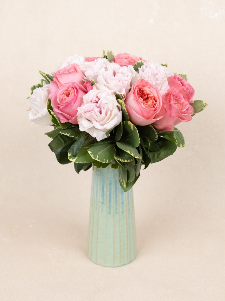 Full 23-stem bouquet of soft pink and blush garden roses with lush greenery, arranged in a tall, textured mint vase for a fresh, elegant look.